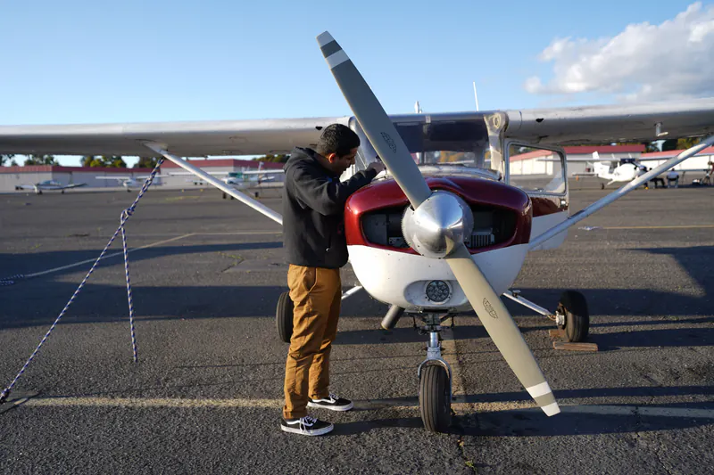 Pilot checking the engine of a Cessna on the ramp